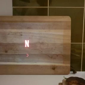 Netflix Projektion auf das Schneidebrett aus Holz auf Kacheln